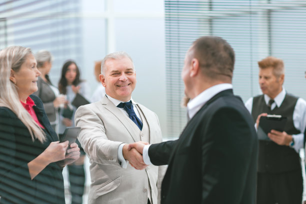 关闭了。同事们在办公室大厅微笑着互相问候图片下载