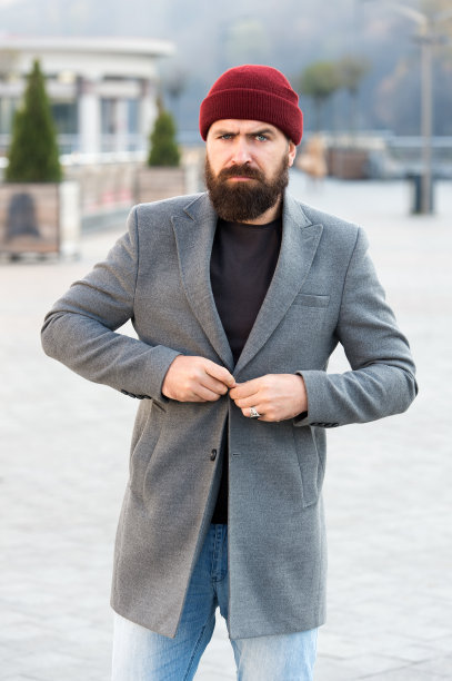 他扣夹克。时髦的服装和帽子配件。时尚休闲装春季。男装和男性时尚概念。留着胡子的男人时髦时髦的外套和帽子。舒适的衣服图片下载
