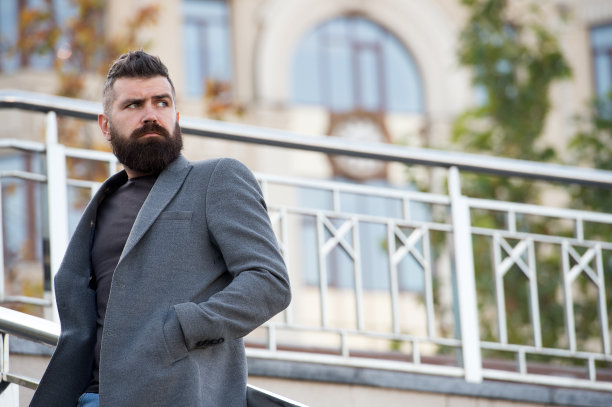 留着胡子的男人，时髦的外表在等人。自信的潮人。潮人自信的户外等待会议。留着胡子的嬉皮士等待伴侣。秋日休闲舒适的服装图片下载