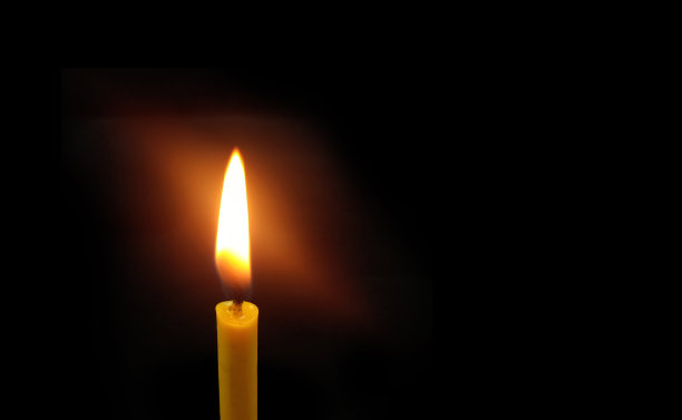 黑色背景上的黄色烛光。图片下载