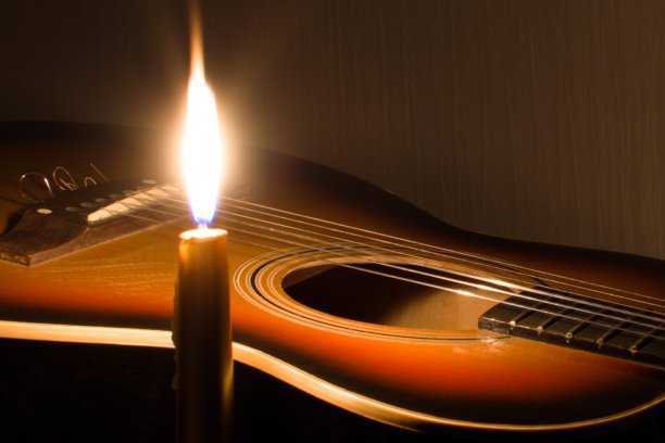在明亮的烛光下弹奏古典吉他图片下载