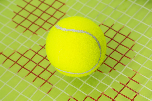 在绿色背景上的网球和球拍。运动的概念。图片下载