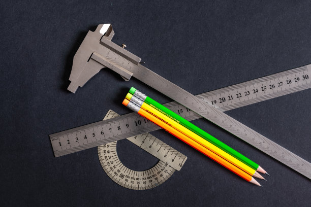 角度计和标尺和游标卡尺三种类型上的深灰色-黑色图案背景。素描铅笔，绿色，黄色，橙色。非彩色，黑白照片。图片下载