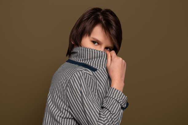 小男孩的肖像在工作室的绿色背景摆姿势。休闲风格。时尚的工作室拍摄图片下载