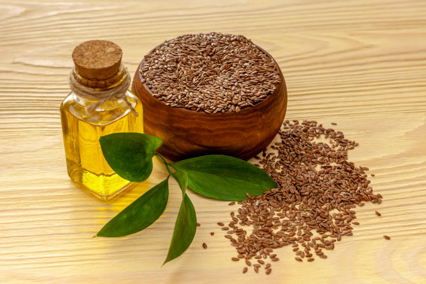 用勺子和碗盛亚麻籽，再加一瓶亚麻籽油图片下载