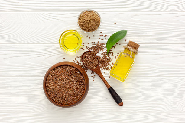 用勺子和碗盛亚麻籽，再加一瓶亚麻籽油图片下载