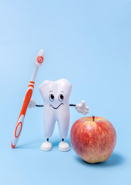 蓝色背景上的牙齿、牙刷和苹果的卡通模型。牙齿健康食品的概念图片下载