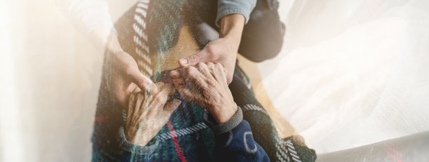 一个面目全非的年轻人牵着一个老妇人的手。图片下载