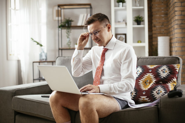 在网上工作的商人，穿西装没穿裤子。有个年轻人在打视频电话。图片下载