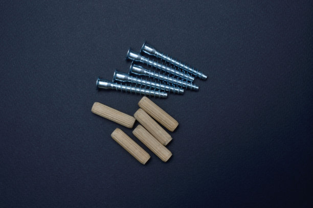 家具螺丝、木销。躺在黑暗的背景上。特写镜头。图片下载