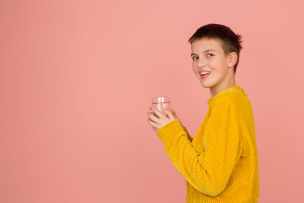 白人女孩的肖像孤立在珊瑚粉红色的工作室背景与拷贝空间图片下载