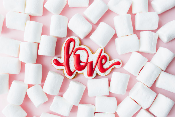 姜饼喜欢配上白色棉花糖。情人节卡片。粉红色的背景图片下载