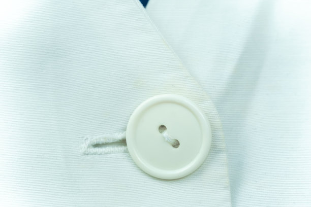特写的白色按钮上的白色医用棉长袍，宏观照片图片下载