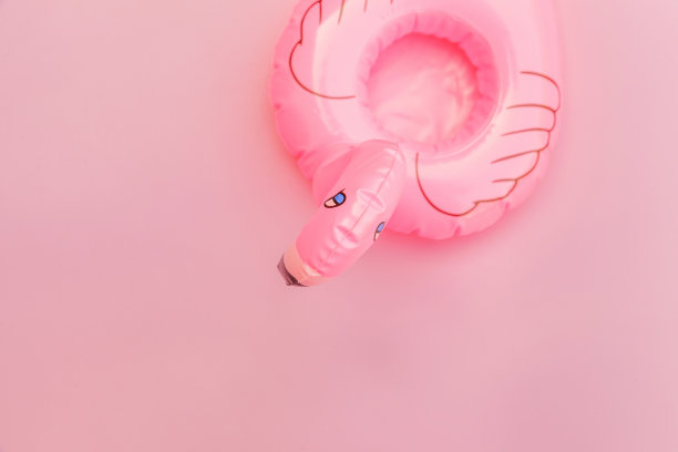 夏天海滩组成。简单的最小设计与充气火烈鸟孤立在柔和的粉红色背景。泳池漂浮派对，时尚名流的时尚概念。平放俯视图拷贝空间图片下载
