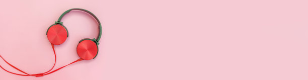 粉色背景的红色耳机。极简简单的照片耳机与复制空间，横幅。红色dj耳机与电缆隔离在彩色的背景下，平躺俯视图。音乐的概念图片下载