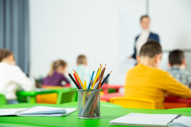 铅笔和笔记本上背景模糊的小学生图片下载