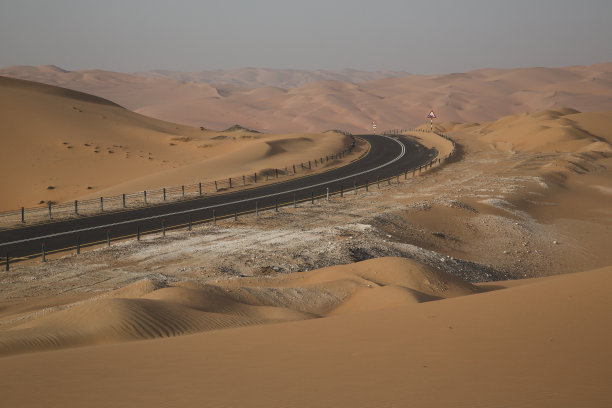 穿越无垠沙漠的空旷道路图片下载