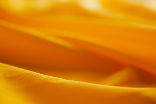 选择柔软的黄色缎纹织物作为背景焦点。图片下载