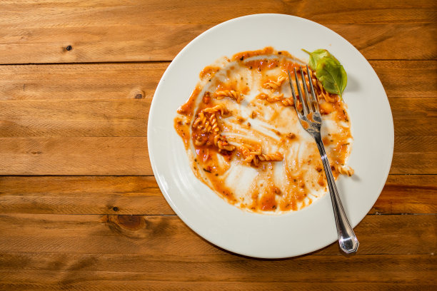 木桌上一盘涂满酱汁的意大利面。图片下载