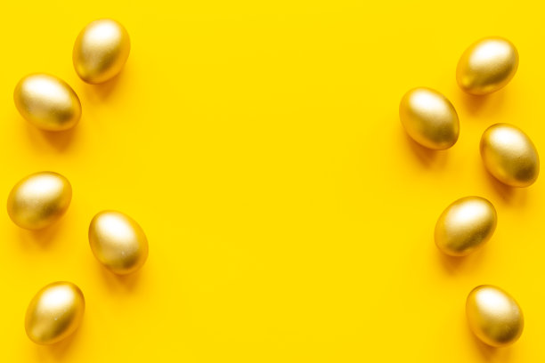 金色的蛋在黄色的上面。复活节装饰背景。俯视图图片下载