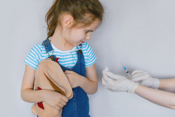 小女孩接种疫苗在工作室隔离白色。大规模接种Covid-19疫苗。图片下载