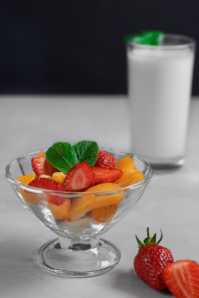 用薄荷装饰的甜点碗里的浆果沙拉。一杯酸奶。健康营养与饮食理念图片下载