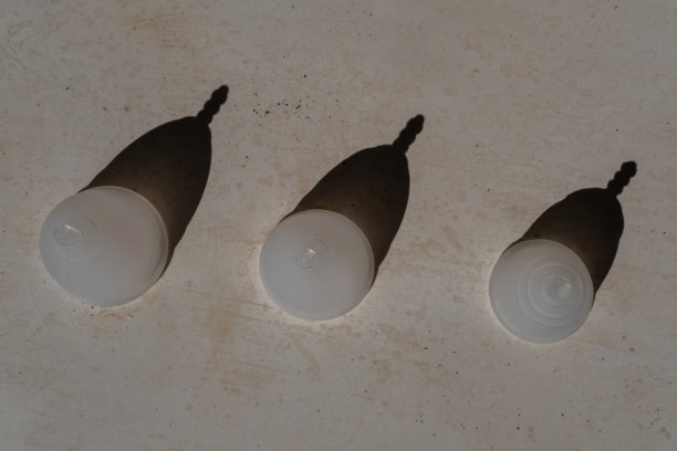 不同大小的硅胶月经杯，在极简的背景与黑暗的阴影。可重复使用的环保女性卫生用品。零浪费、可持续、无塑料的生活方式图片下载