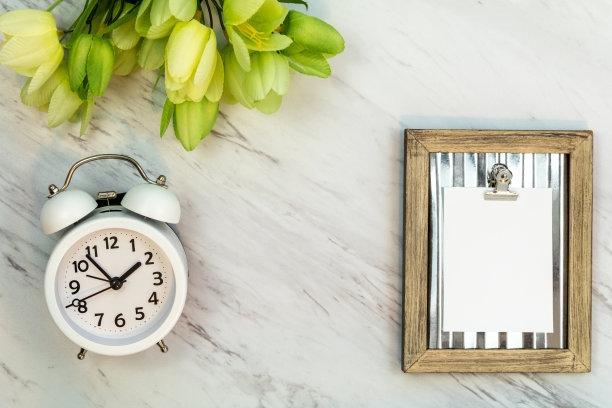 白色空白的笔记模型上大理石闹钟郁金香平铺图片下载