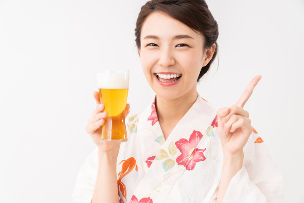 亚洲妇女穿着传统的日本休闲夏季和服“浴衣”，喝啤酒图片下载