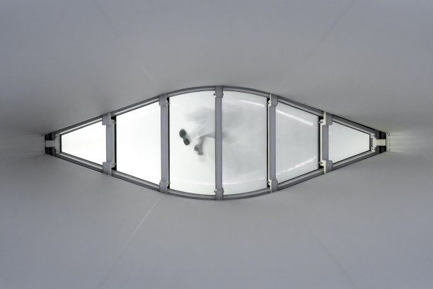 透过地板上的钻石磨砂玻璃窗，可以看到行人的鞋印，在支撑有机玻璃罩的栏杆上留下了鞋印的剪影图片下载