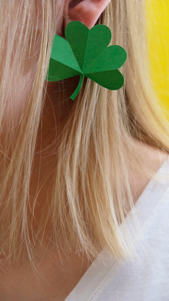三叶草就像女孩的耳环。圣帕特里克节的概念。图片下载