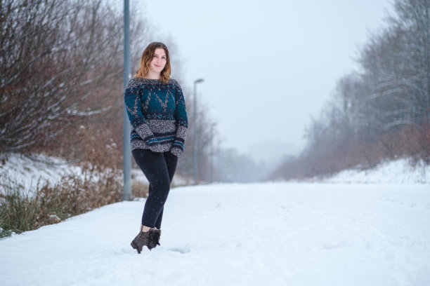 美丽微笑的千禧女孩在冬日的雪天看着相机图片下载