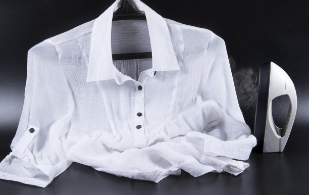 可携带的家和服装蒸笼的衣服和白色衬衫衣架上的黑色背景。用熨斗做家务图片下载