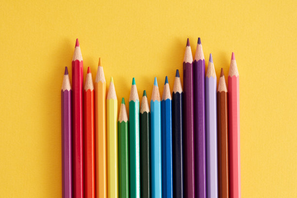 黄色背景上的彩色铅笔。图片下载