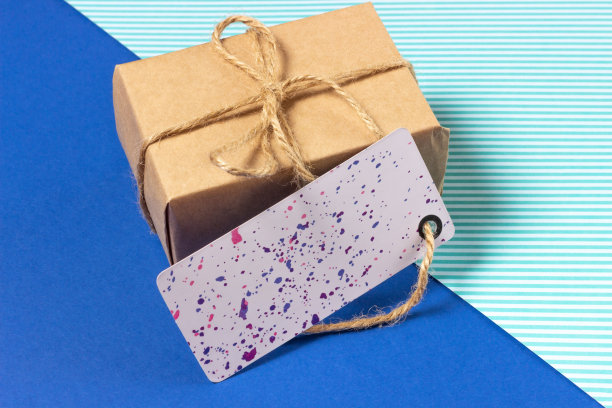 蓝底牛皮纸包装的礼盒。俯视图，假日概念。图片下载