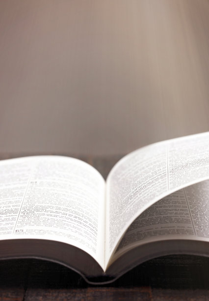 在质朴的木桌上打开圣经，书页被吹开图片下载