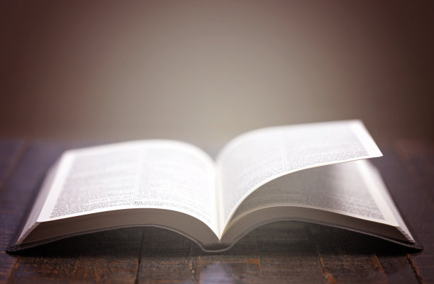 在质朴的木桌上打开圣经，书页被吹开图片下载