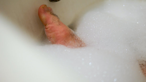 在浴缸里泡脚的男人图片下载