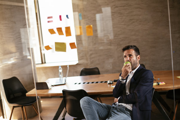 会议室的商人在玻璃墙上使用便利贴。图片下载