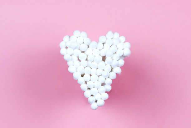 粉色背景的白色棉质耳塞。图片下载