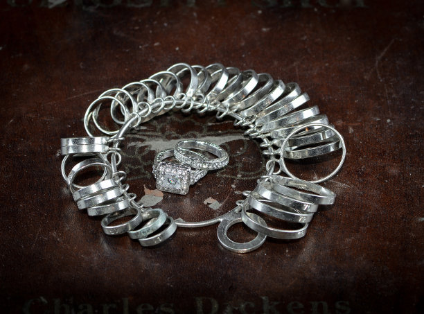 两枚白色钻戒和几种不同尺寸的金属戒指。图片下载