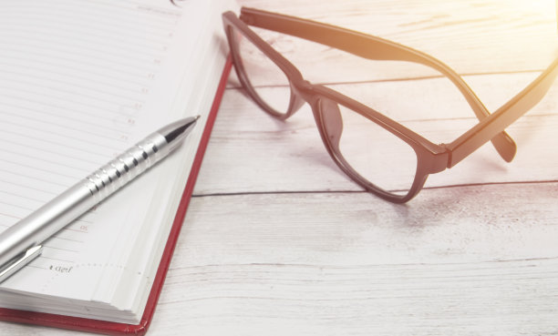 笔在记事本上，眼镜在桌面上，在办公室商务或教育作文俯视图图片下载