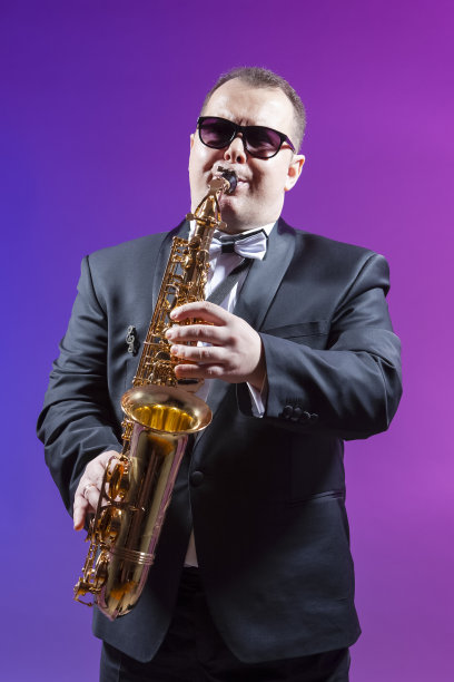 音乐家的概念。成熟的富有表现力的白种人萨克斯管演奏家的肖像在多彩的背景下。垂直的原料油图片下载