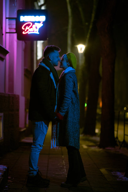 美丽的情侣站在夜晚的城市街道上图片下载