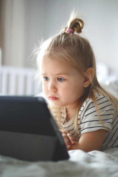 小女孩在家看平板电脑。家庭教育，远程教育图片下载