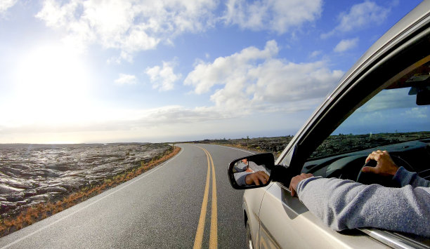 日出时分，一辆汽车沿着开阔的道路行驶图片下载