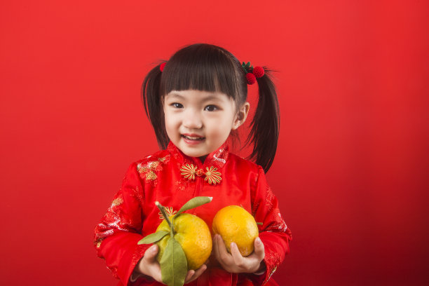 一个中国女孩拿着橘子过春节素材图片