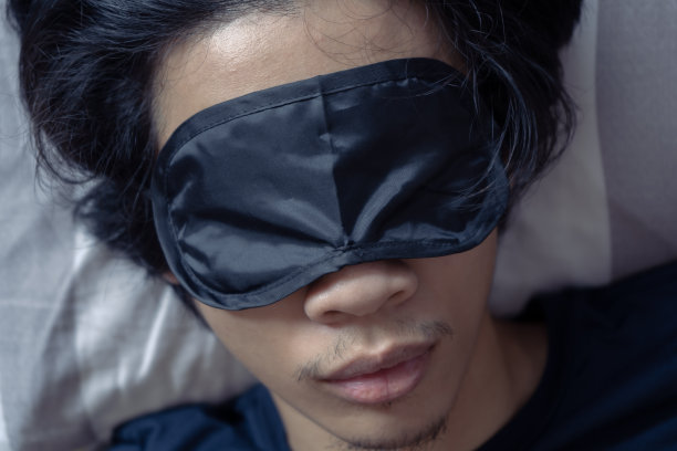 一个戴着睡眠面罩睡觉的男人图片下载
