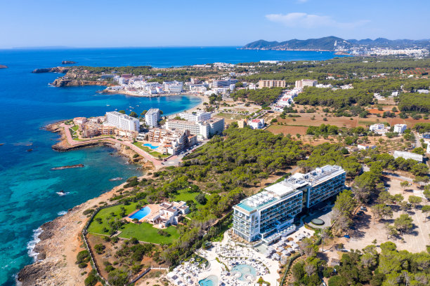 这是西班牙伊比沙岛美丽的无人机拍摄的照片，在一个炎热阳光明媚的夏日，海边金色的沙滩上，人们在放松和日光浴图片下载