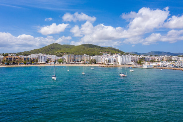 这是西班牙伊比沙岛美丽的无人机拍摄的照片，在一个炎热阳光明媚的夏日，海边金色的沙滩上，人们在放松和日光浴图片下载